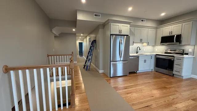 a kitchen with stainless steel appliances granite countertop a refrigerator and a stove top oven