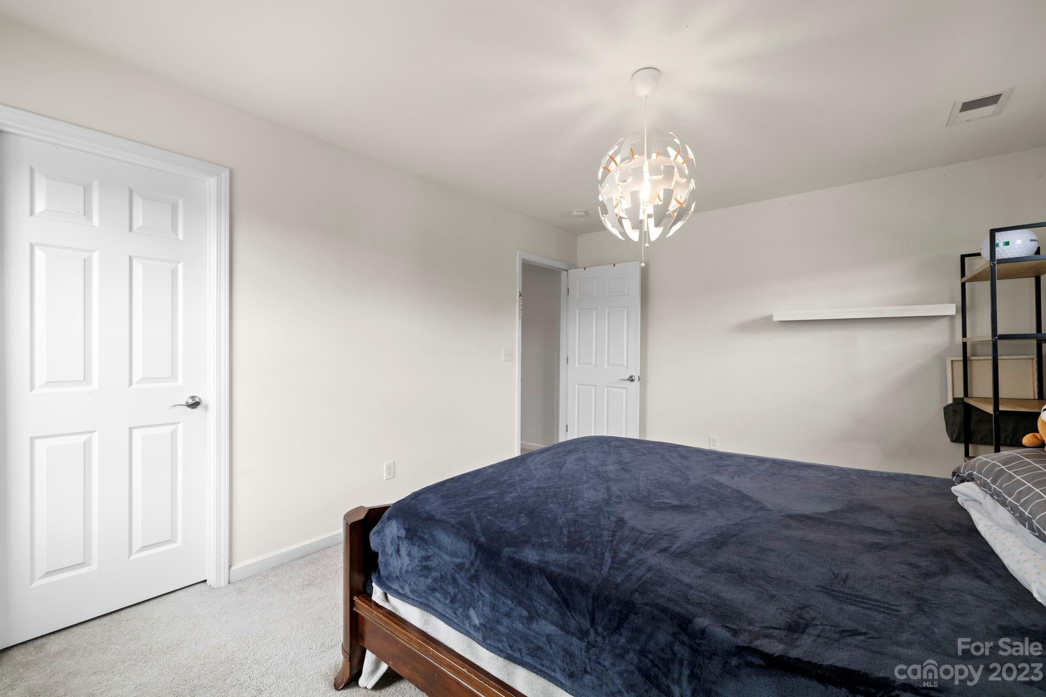 59 North River Road Fletcher, NC 28732 - Photo 29 of 36 a bedroom with a bed and a chandelier