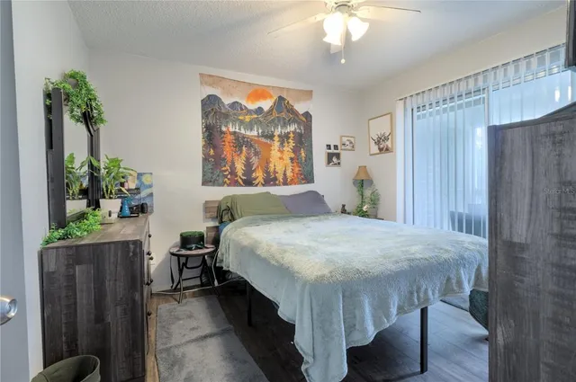 a bedroom with a bed table and a potted plant