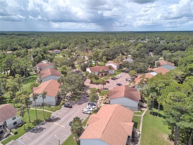 an aerial view of residential houses with outdoor space and trees