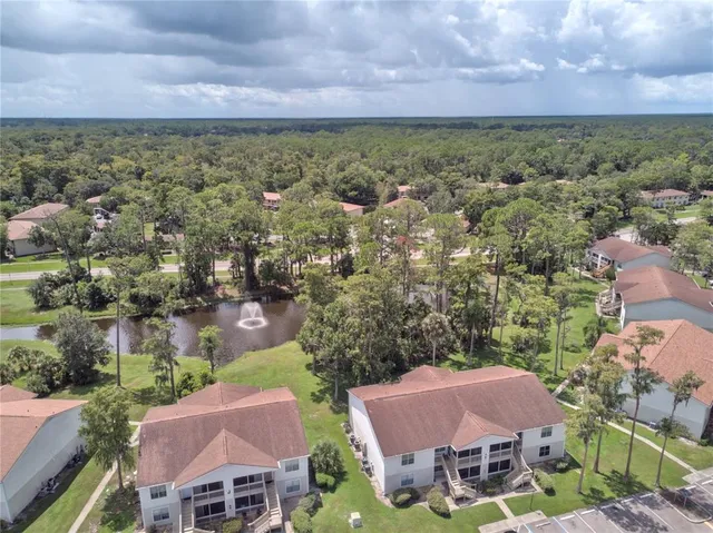 an aerial view of residential houses with outdoor space and trees