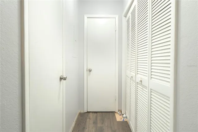 a view of a hallway with wooden floor and closet