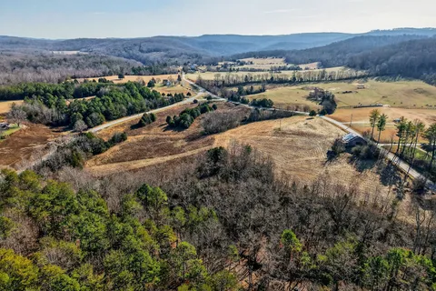 an aerial view of a house with a yard and mountain view in back