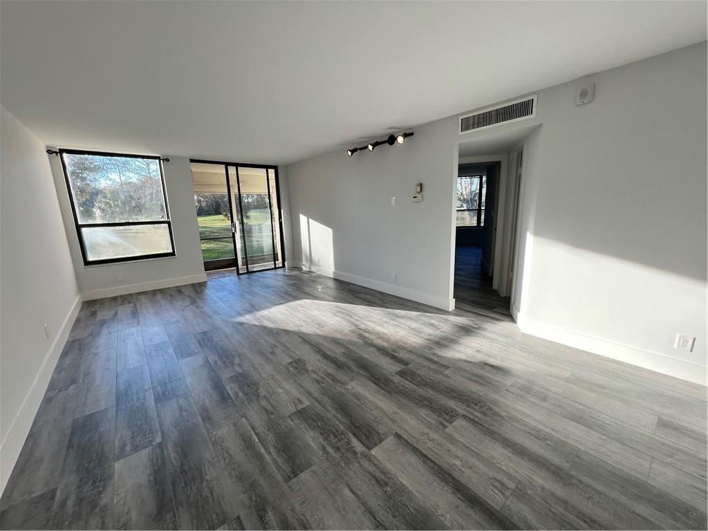 6451 North University Drive, Unit 112 Tamarac, FL 33321 - Photo 13 of 21 wooden floor in an empty room with a window