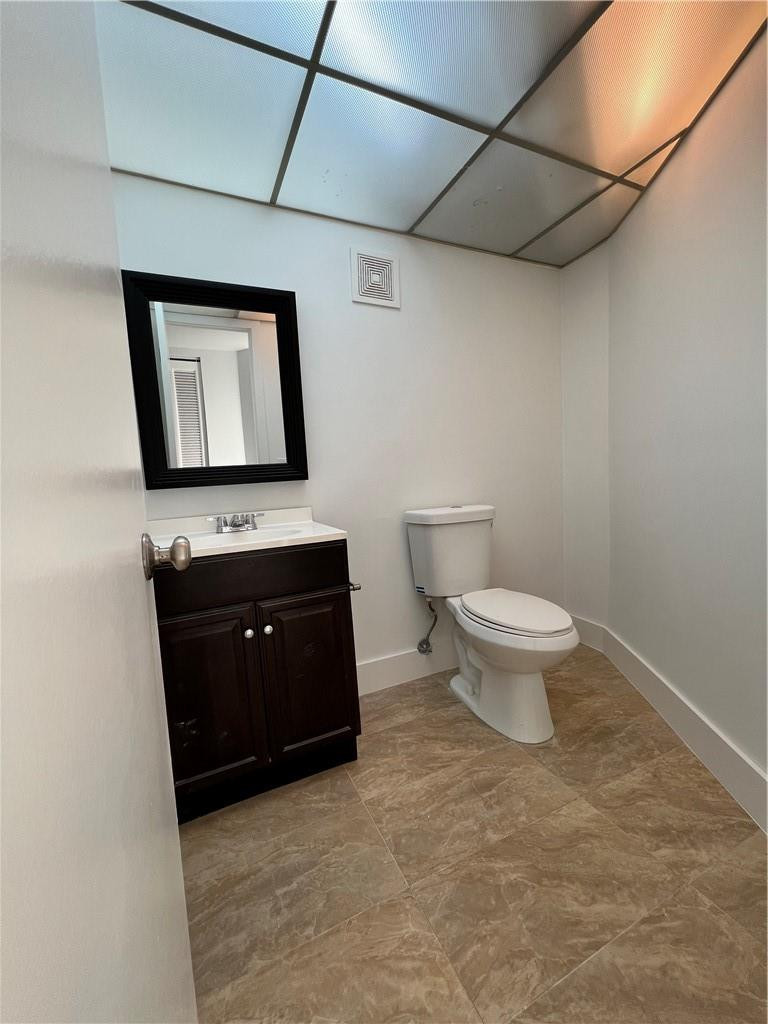 6451 North University Drive, Unit 112 Tamarac, FL 33321 - Photo 15 of 21 a bathroom with a toilet sink and mirror