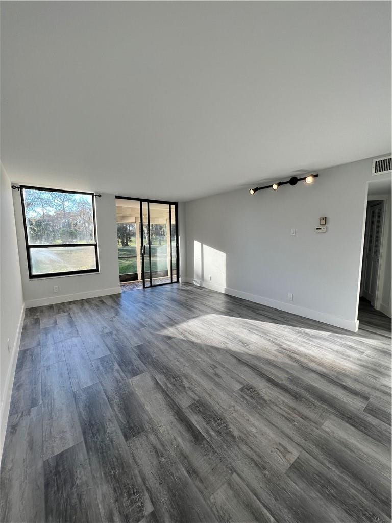 6451 North University Drive, Unit 112 Tamarac, FL 33321 - Photo 21 of 21 an empty room with wooden floor and windows