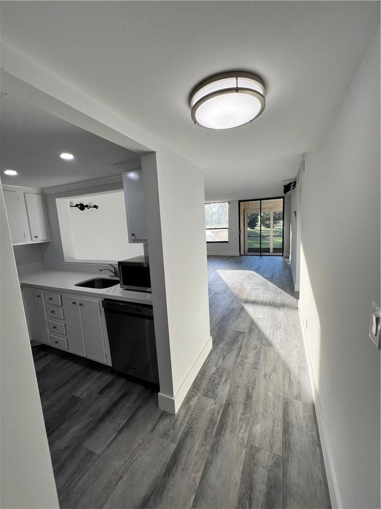 6451 North University Drive, Unit 112 Tamarac, FL 33321 - Photo 4 of 21 a view of a kitchen with kitchen island wooden floor center island and stainless steel appliances