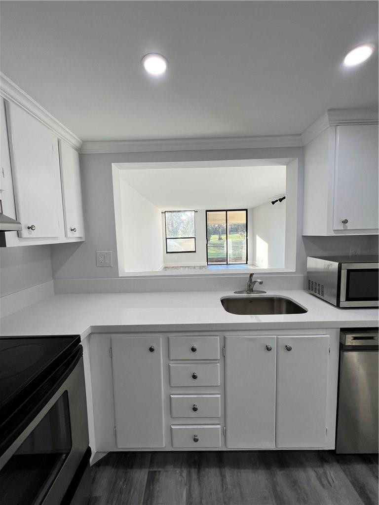6451 North University Drive, Unit 112 Tamarac, FL 33321 - Photo 8 of 21 a kitchen with white cabinets and sink