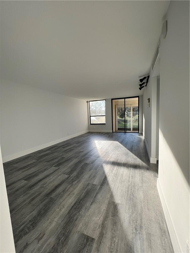 6451 North University Drive, Unit 112 Tamarac, FL 33321 - Photo 9 of 21 a view of wooden floor and windows in a room