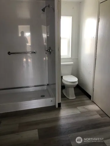 a bathroom with a toilet a sink and shower