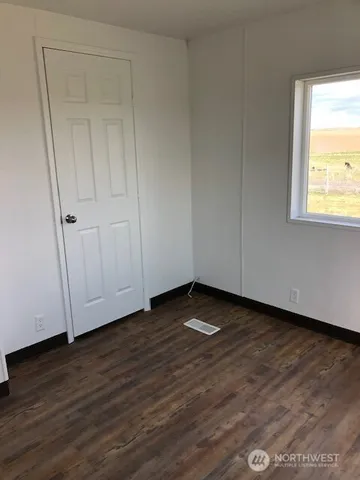 a view of an empty room and wooden floor