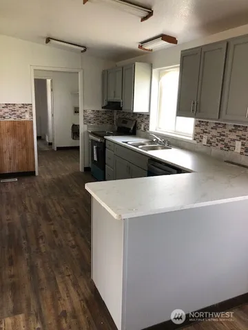 a kitchen with stainless steel appliances a sink a stove a refrigerator a sink a counter space and cabinets