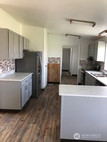 a kitchen with refrigerator and cabinets