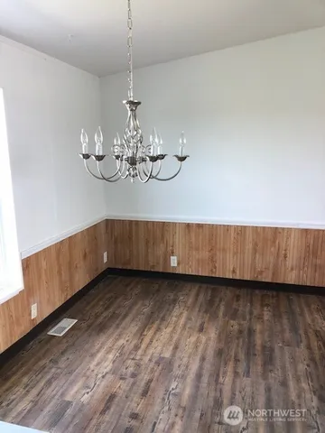 a view of a room with wooden floor and chandelier