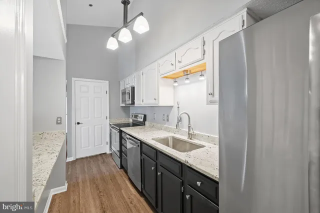 a kitchen with a sink dishwasher a refrigerator with wooden floor