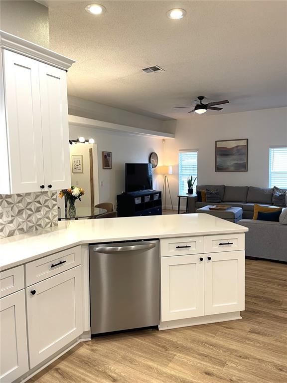 5941 Velvet Loop Lakeland, FL 33811 - Photo 33 of 61 a view of a kitchen with stainless steel appliances granite countertop a stove a sink and white cabinets with wooden floor