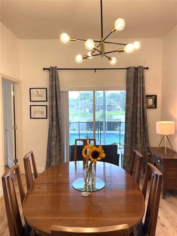 5941 Velvet Loop Lakeland, FL 33811 - Photo 37 of 61 a view of a dining room with furniture a chandelier and large windows