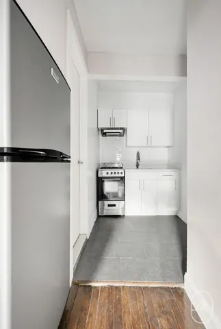 a view of an empty room with wooden floor and stairs