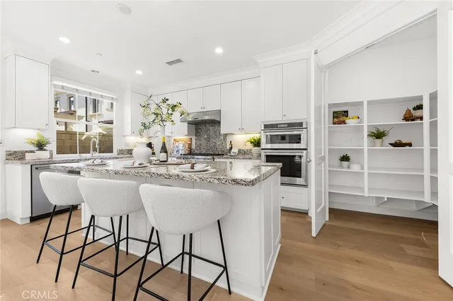 a large white kitchen with granite countertop a lot of counter space
