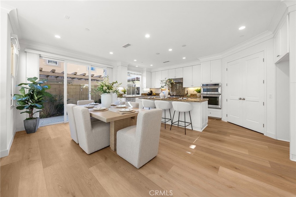 112 Velvetleaf Irvine, CA 92620 - Photo 10 of 51 a living room with stainless steel appliances kitchen island granite countertop a table chairs and a refrigerator