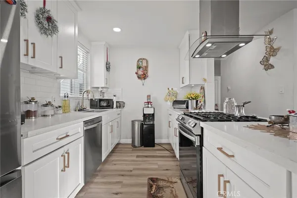 a kitchen with stainless steel appliances kitchen island granite countertop a refrigerator and a stove top oven
