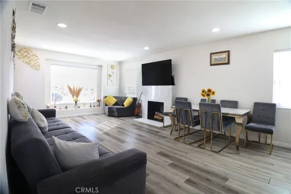 a living room with furniture a flat screen tv a lamp and a window