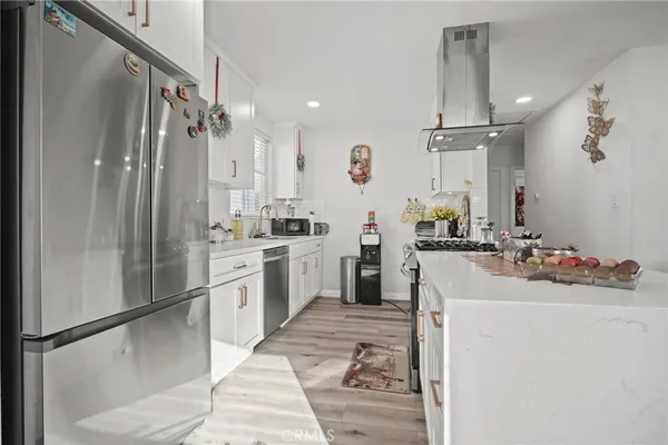 a kitchen with appliances cabinets and a potted plant
