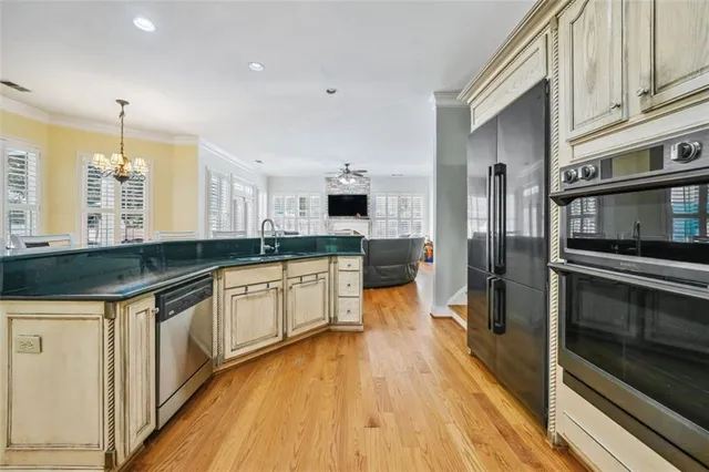 a large kitchen with stainless steel appliances a large counter top a stove a refrigerator and a sink