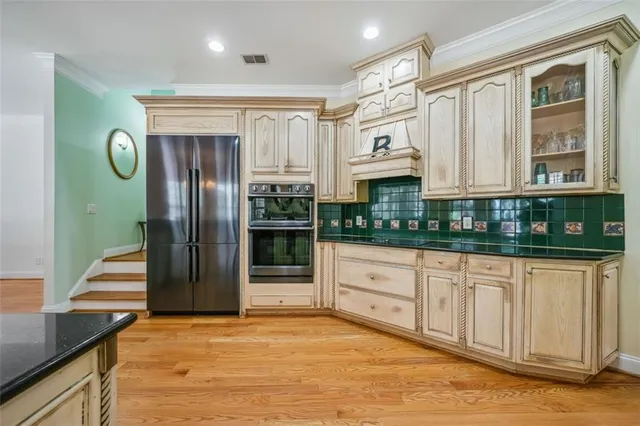 a kitchen with stainless steel appliances granite countertop a refrigerator and a stove