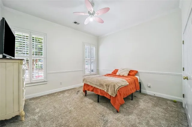 a bedroom with a bed and a flat tv screen on dresser
