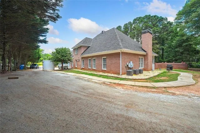a view of a house with a yard and large tree