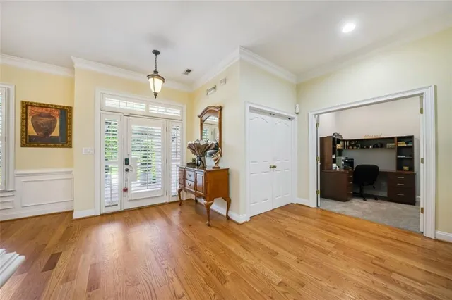 a view of a big room with wooden floor cabinet and windows