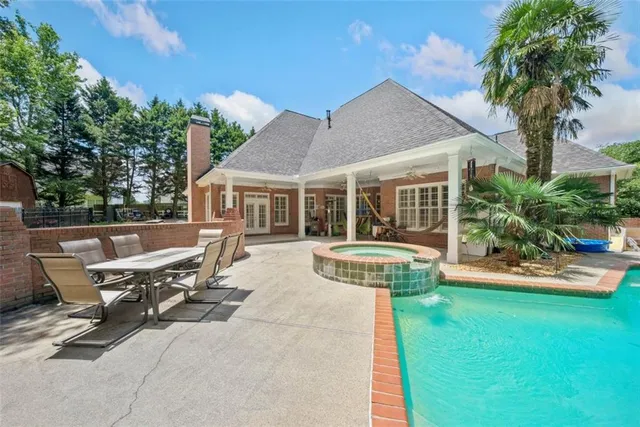 a view of a house with sitting area and swimming pool