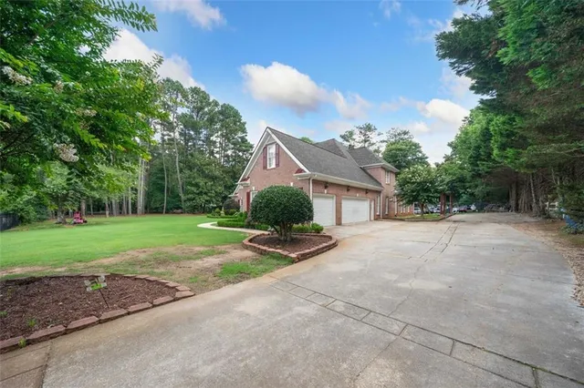 a view of a house with backyard and trees