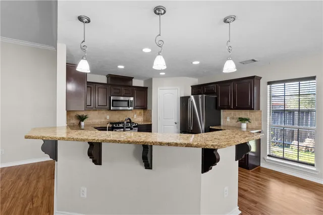 a large white kitchen with a large counter top appliances and cabinets