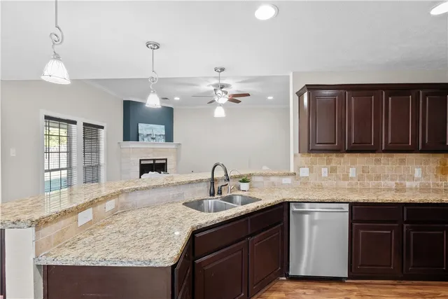 a kitchen with stainless steel appliances granite countertop a sink a stove a refrigerator and wooden floor