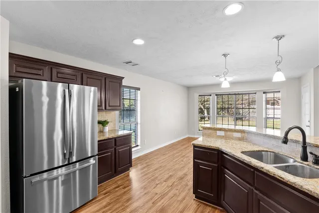 a kitchen with granite countertop wood cabinets and stainless steel appliances