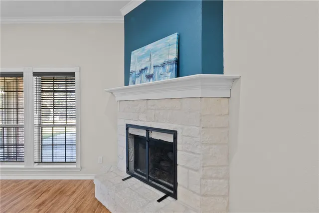 a view of an empty room with exposed radiator and fireplace