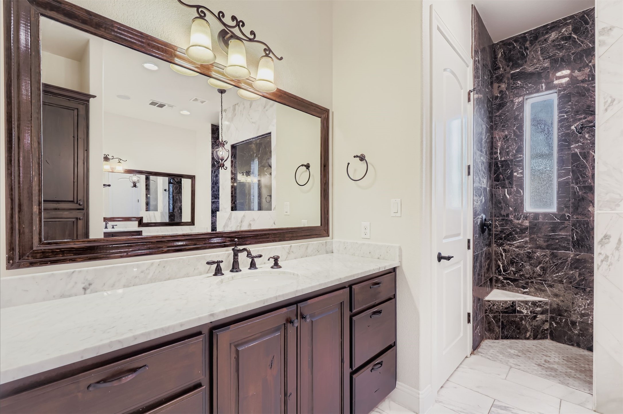 1415 Roaring Fork Leander, TX 78641 - Photo 12 of 39 Full bathroom with second vanity, light marble floors, and a marble finish shower