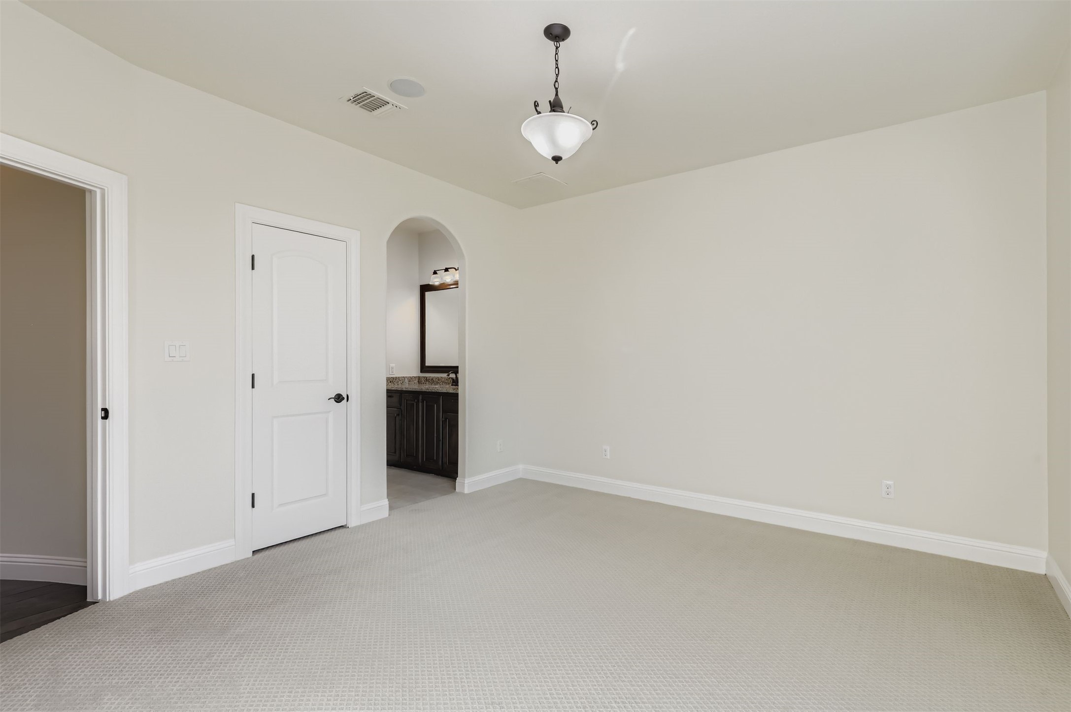 1415 Roaring Fork Leander, TX 78641 - Photo 20 of 39 Unfurnished bedroom with light carpet, ensuite bath, and arched walkways