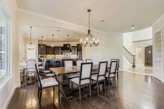 a view of a dining room and livingroom with furniture wooden floor a chandelier