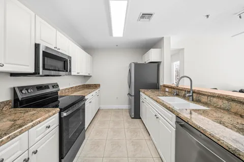 a large kitchen with stainless steel appliances granite countertop a sink and a stove
