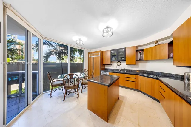 a view of a kitchen with kitchen island granite countertop a sink and a counter top space