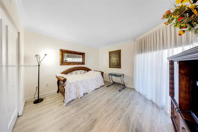 a bedroom with a bed table and a flat screen tv