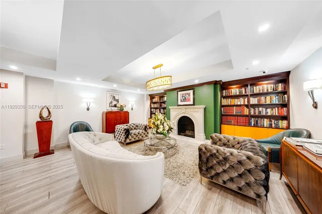 a living room with furniture a chandelier and a floor to ceiling window
