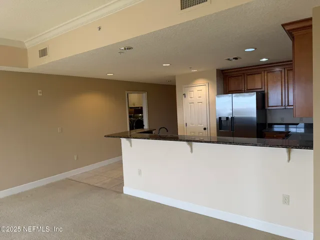 a view of a kitchen with a sink and a refrigerator