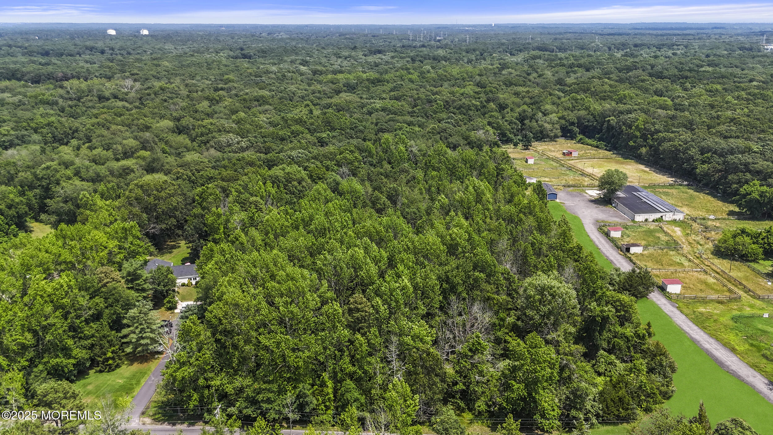 an aerial view of residential houses with outdoor space and trees