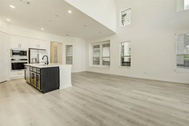 a kitchen with stainless steel appliances granite countertop a stove top oven a sink a counter space and cabinets