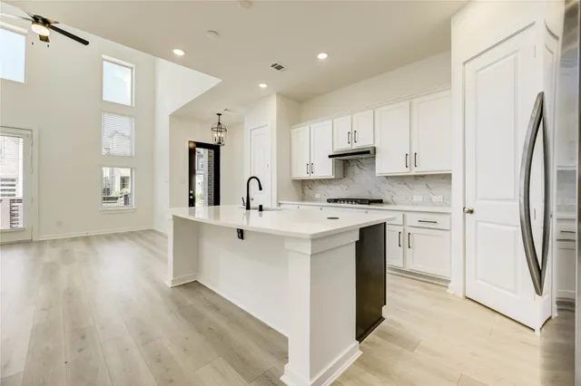 a kitchen with white cabinets and stainless steel appliances