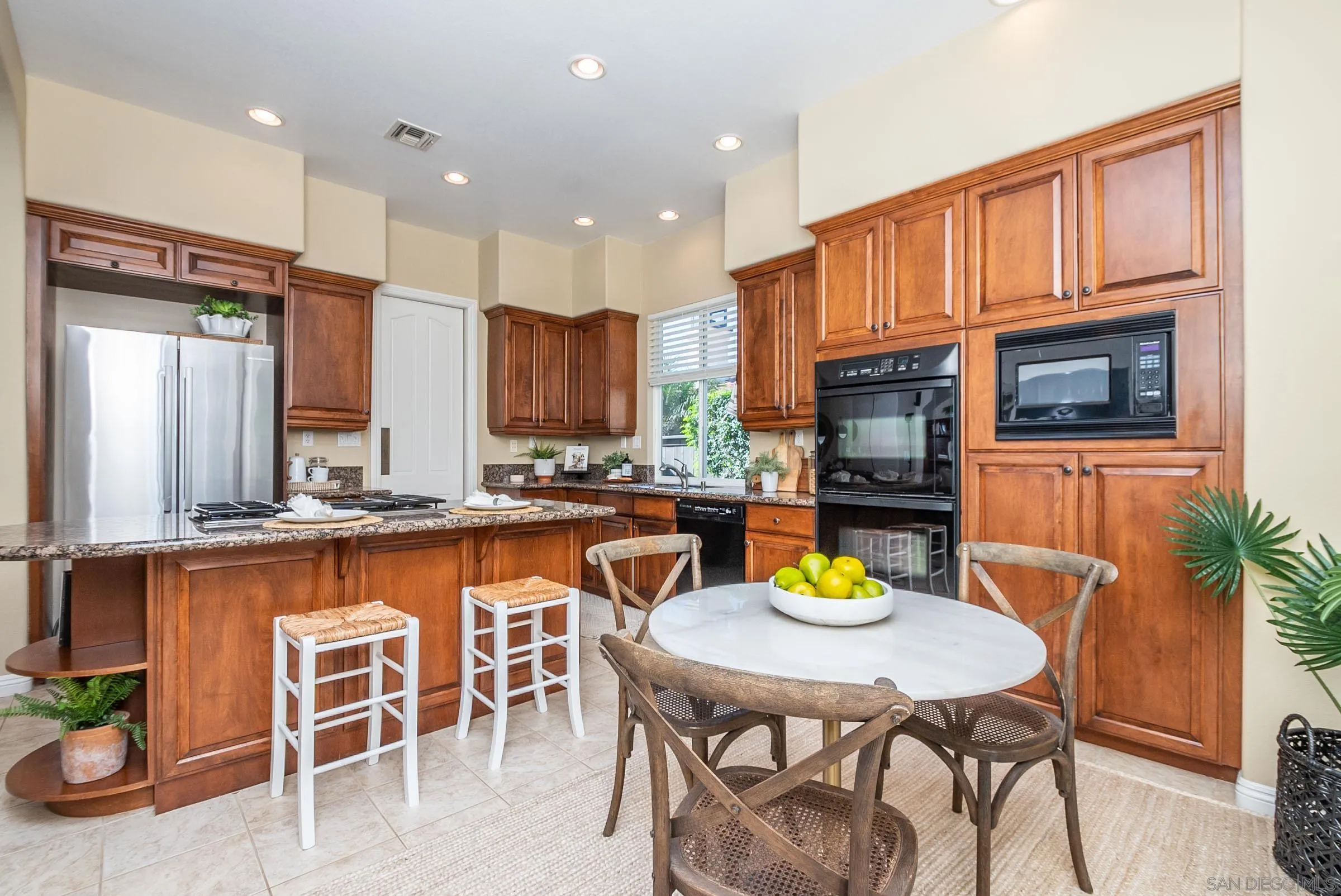 3008 Via Conquistador Carlsbad, CA 92009 - Photo 3 of 31 a kitchen with granite countertop a table chairs microwave and cabinets